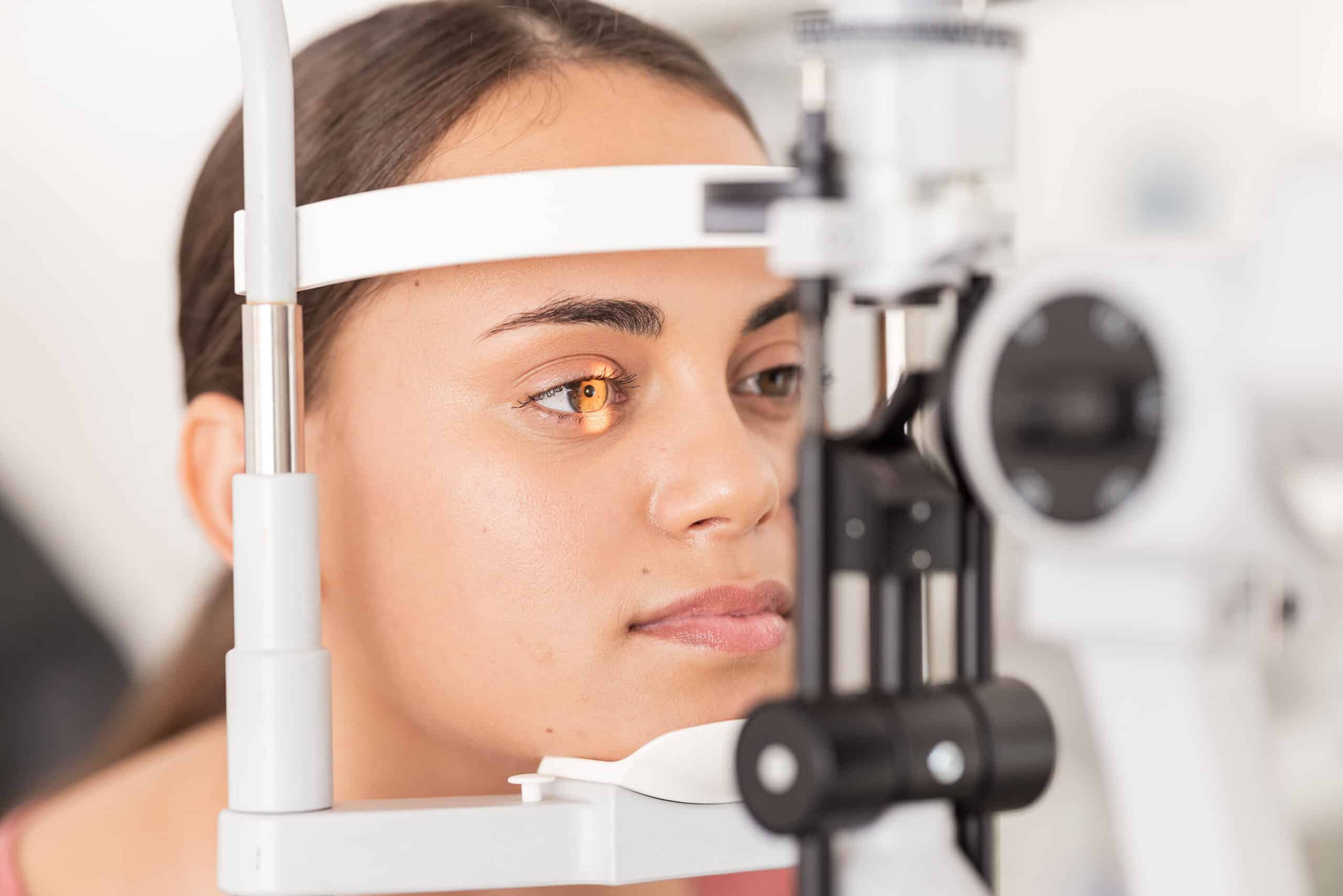 Healthcare, eyes and woman eye test at a clinic for vision, health and eyesight on a slit lamp examination. Face, eye care and girl consulting optometrist for sight, wellness and glaucoma testing.
