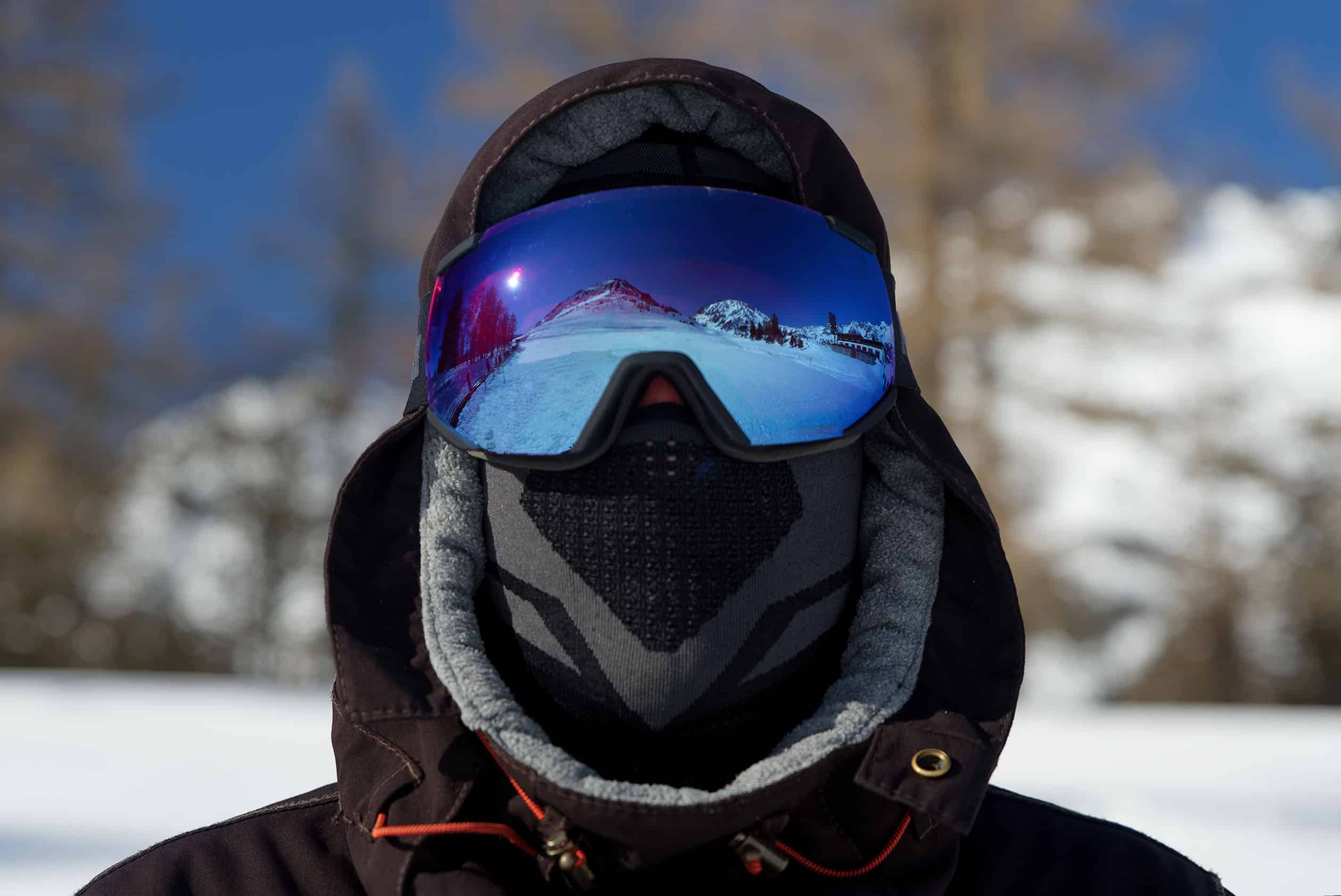 Portrait masculin sous masque de snow avec reflet de la montagn